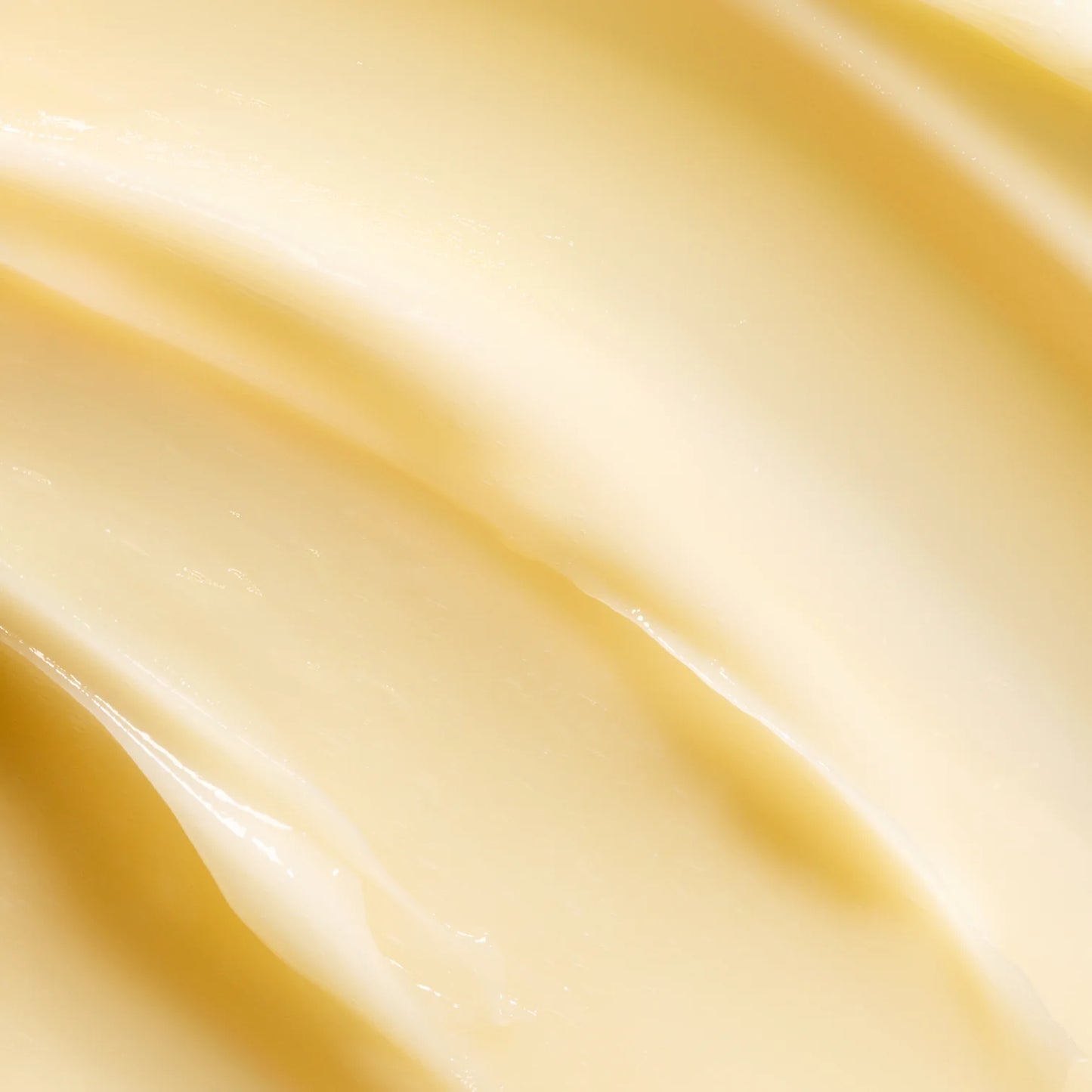 Close-up of creamy, smooth, pale yellow Lumene Nordic-C Strength & Shine 2-in-1 Hair Mask by Lumene, featuring a soft, wavy texture and enriched with vitamin C.
