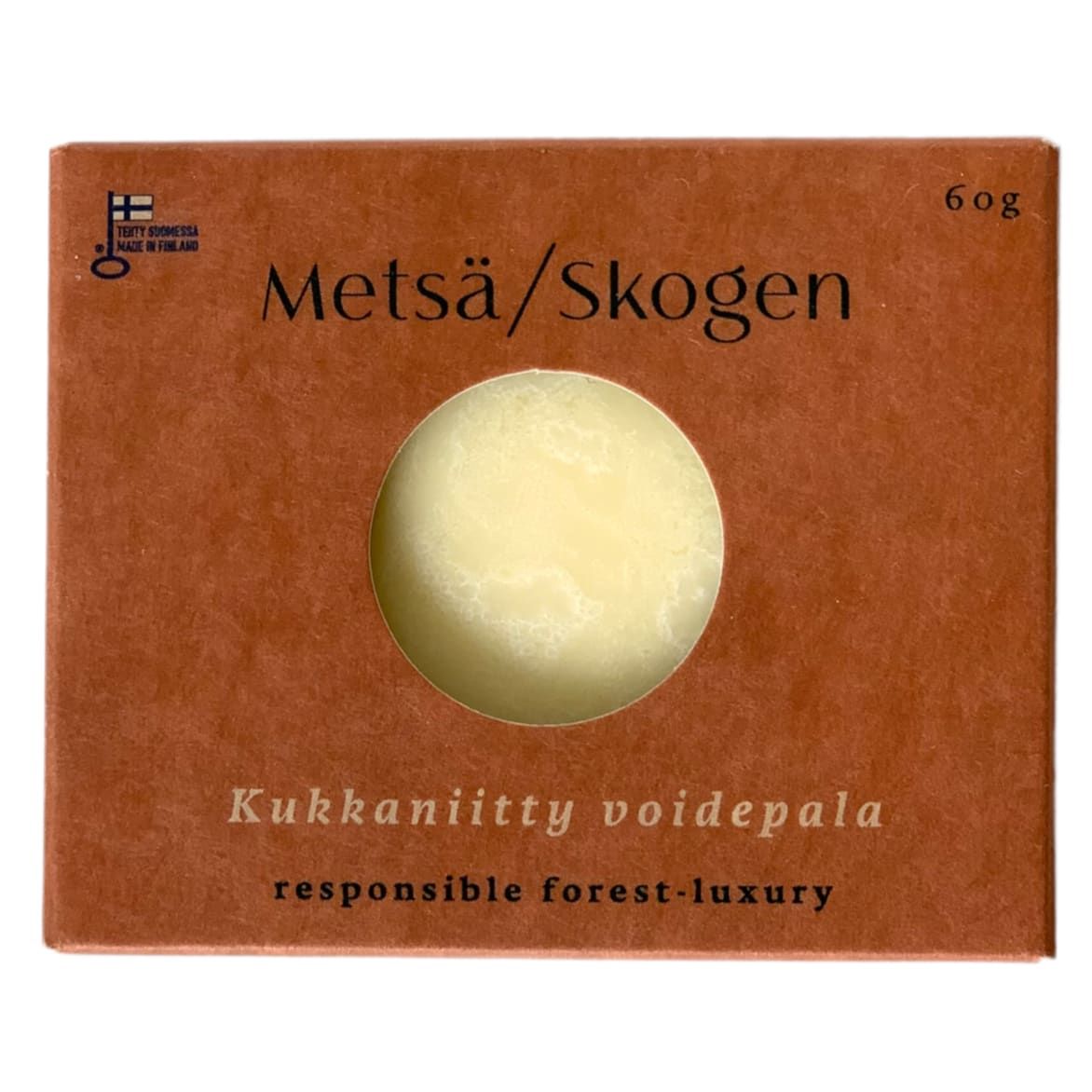 A brown box with a circular window reveals the Metsä/Skogen Wild Flower Field Cream Bar, a round pale yellow cream bar. The box notes it’s responsible forest-luxury, handcrafted in Finland, and is labeled 60g.