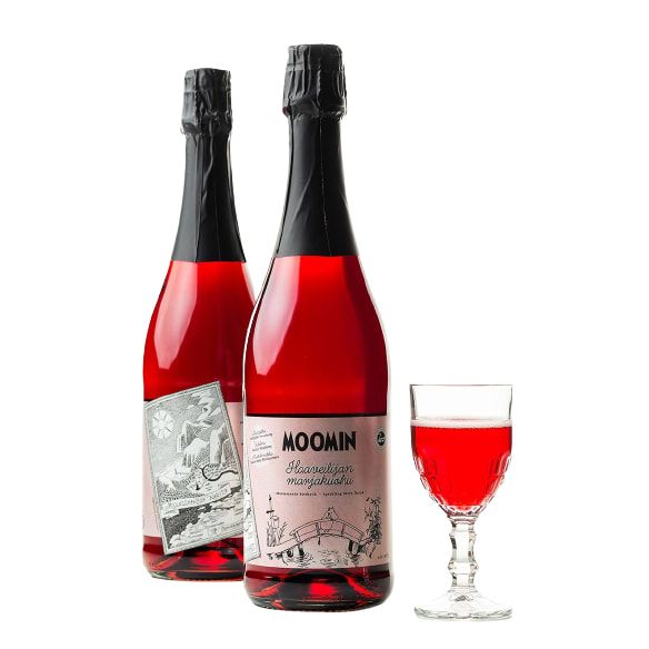 Two bottles of Poikain Parhaat Moomin Sparkling Drink 0,0 %, with illustrated labels, stand by a glass filled with the same bright red Finnish berry drink, all set against a plain white background.