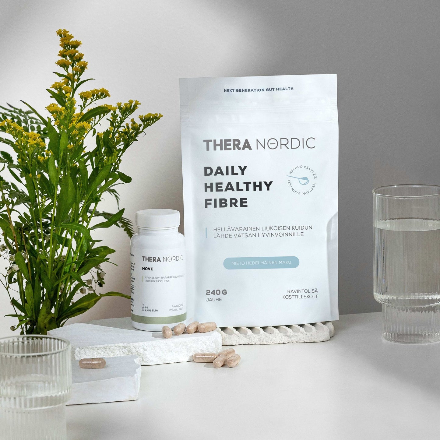 Thera Nordic Daily Healthy Fibre packaging on a white surface with a plant and glass of water in the background.