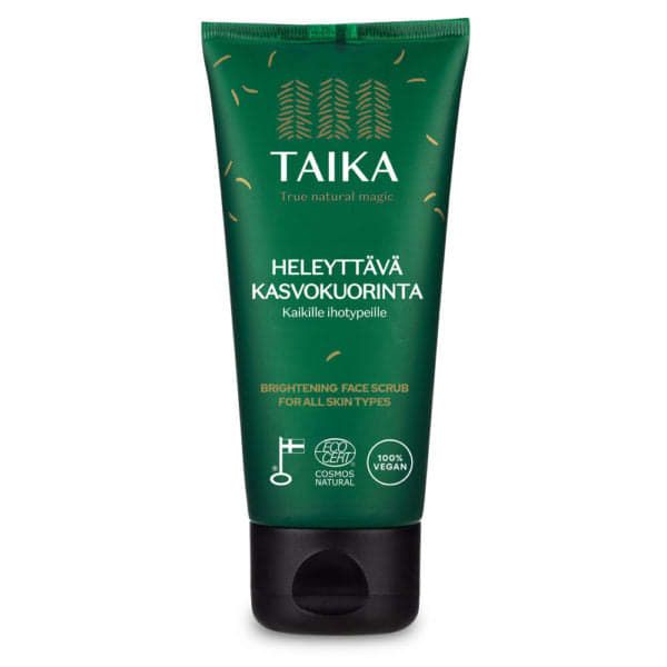 A green tube of Taika Brightening Face Scrub for all skin types, with Finnish and English text, eco-certification logos, and a black capâmoisturizing exfoliation leaves skin smooth and radiant.