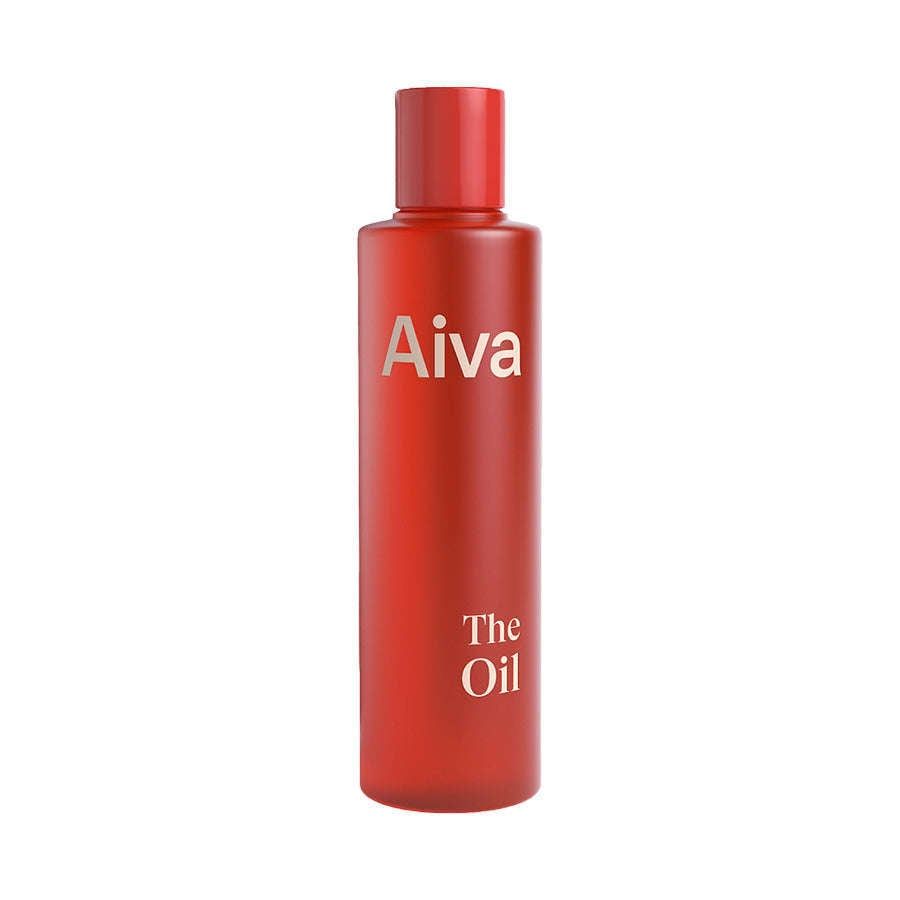 A tall, sleek red bottle labeled "Aiva" at the top and "The Oil" at the bottom contains Aiva The Oil organic care oil with bilberry seed oil, placed against a plain white background.