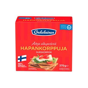 A red box of Oululainen Crisp Bread, made by Oululainen, features a photo of whole grain rye crisp bread with cheese, cucumber, tomato, and herbs. A small Finnish flag appears in the lower left corner. High in fibre.