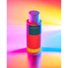 A vibrant Djusie Acid Bloom Balancing Essence bottle stands upright against a multicolored backdrop, highlighting this Djusie essence’s brightening effect and support for the skin’s natural pH balance.