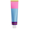 A tube with a pink, blue, and purple color block design stands upright with a white cap. “Djusie” is partially visible near the bottom—perfect for your deeply nourishing skincare routine with the Djusie Juicy Skin Box.