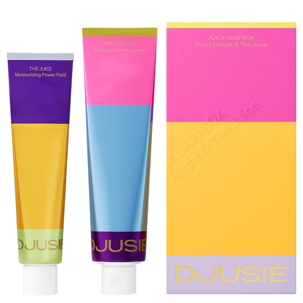 Two colorful tubes—THE JUICE Moisturizing Power Fluid and CITRUS DELIGHT Cleansing Cream—stand beside a vibrant box labeled Djusie Juicy Skin Box. Experience deeply nourishing Djusie skincare in every set.