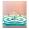 Goodio Calm & Balanced chocolate bar packaging, featuring a soft pink and peach background with gold foil text and a stylized teal and pink droplet over concentric ripples in shades of teal and white.