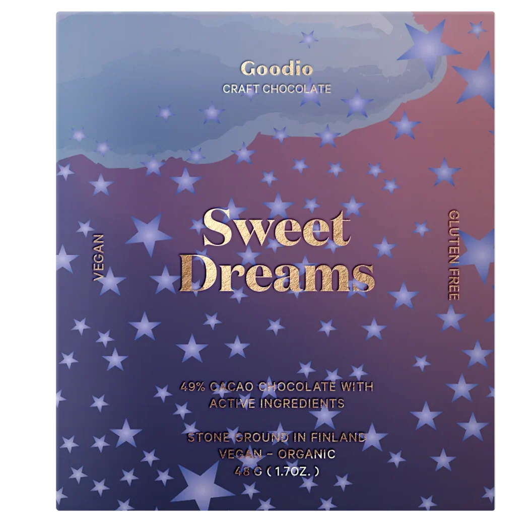A square chocolate bar package labeled Goodio Sweet Dreams, featuring a purple-to-pink gradient background with scattered white stars and gold text. Visible text includes 'Goodio Craft Chocolate,' 'Sweet Dreams,' 'Vegan,' and 'Gluten Free.