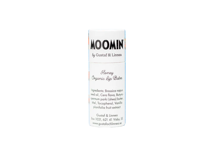 A white cylindrical tube labeled Gustaf & Linnea Moomin Lipbalm Moominmamma contains eco-friendly lip balm, with an ingredient list and contact details printed below. The tube is shown against a plain white background.