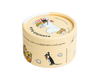 A round, yellow eco-friendly tin of Gustaf & Linnea Moominmammas Marigold Balm features whimsical animal illustrations, including a white creature on the lid and a black creature with a flower, plus shells and floral accents.