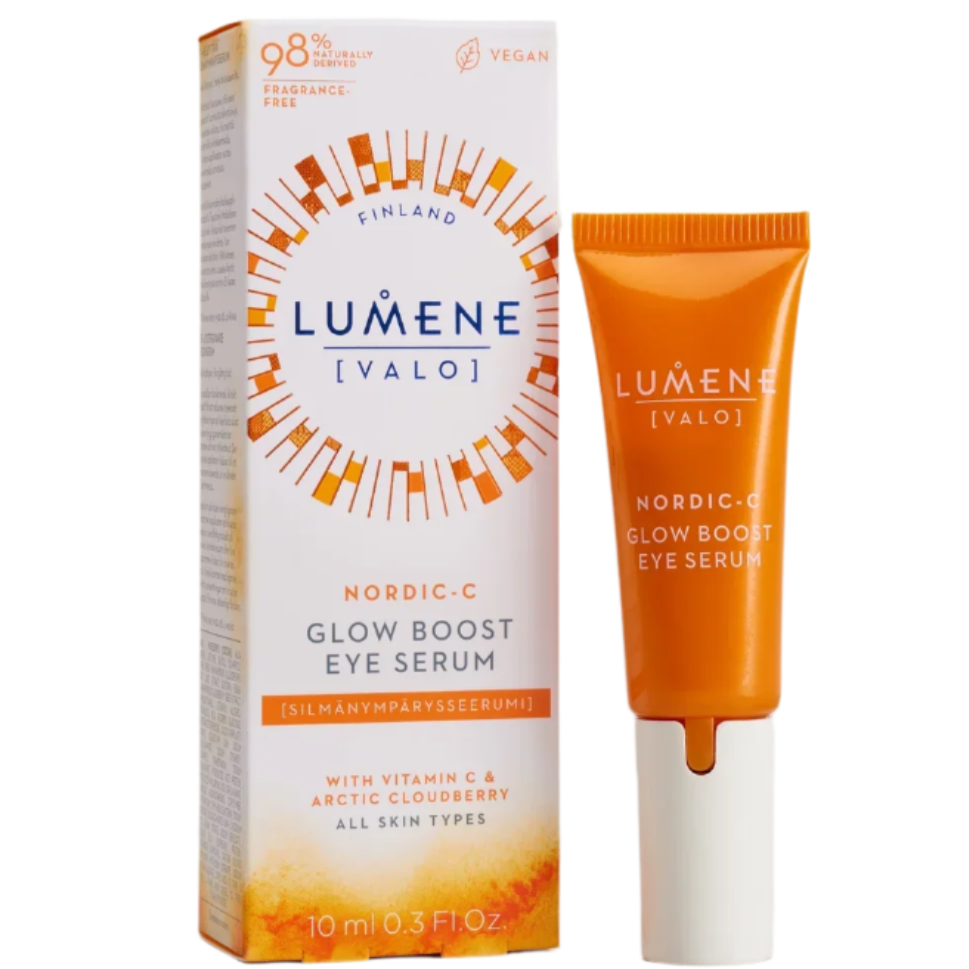 A Lumene Nordic-C Glow Boost Eye Serum in an orange tube stands beside its white and orange box, labeled vegan and featuring vitamin C and arctic cloudberry to brighten dark circles for all skin types.