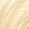 Close-up of Lumene Nordic-C Strength & Shine Conditioner by Lumene—a creamy, light yellow conditioner with a smooth, glossy texture and visible ridges spread on a flat surface.