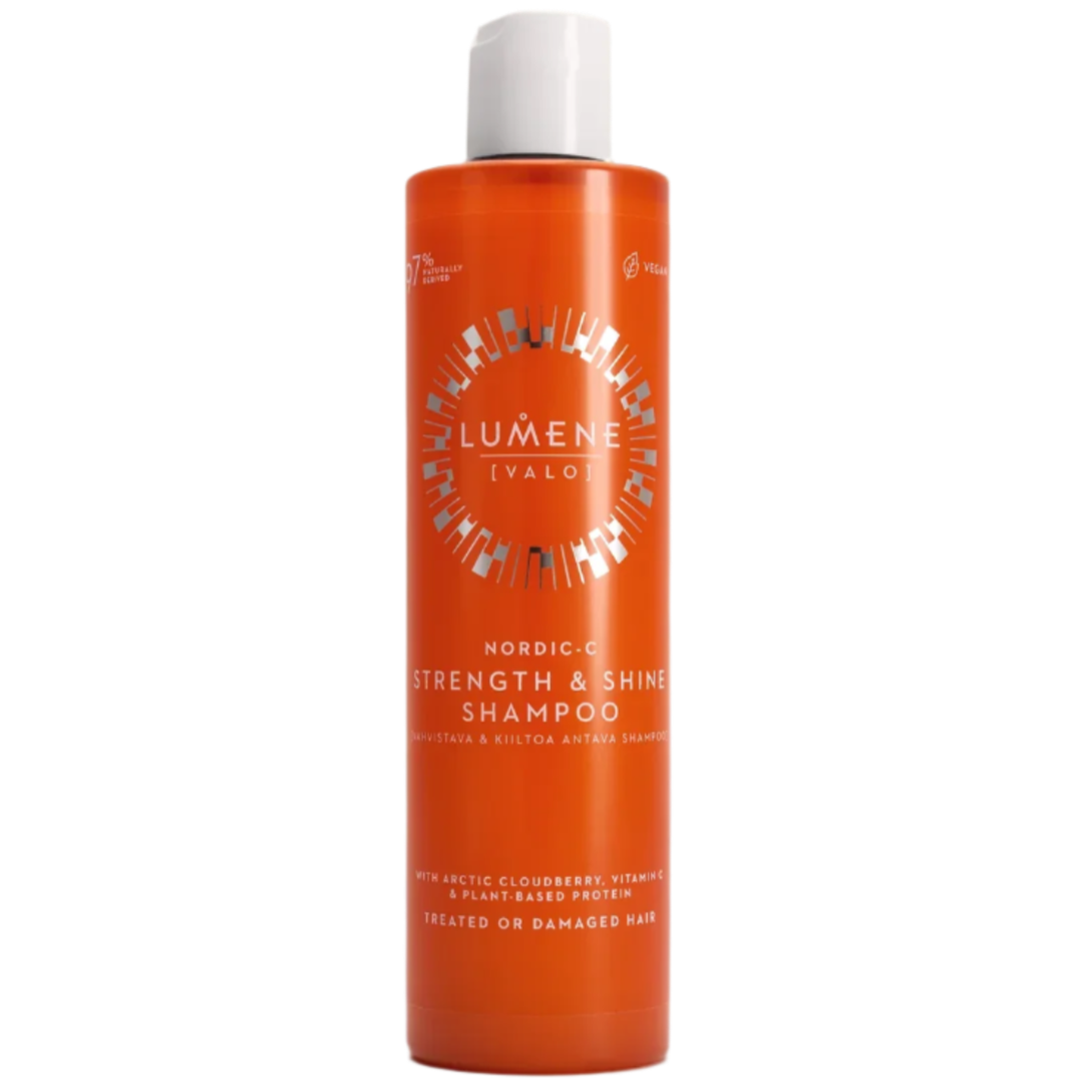 An orange bottle of Lumene Nordic-C Strength & Shine Shampoo for treated or damaged hair, featuring white text and cap. The label highlights arctic cloudberry, vitamin C, and plant-based protein.