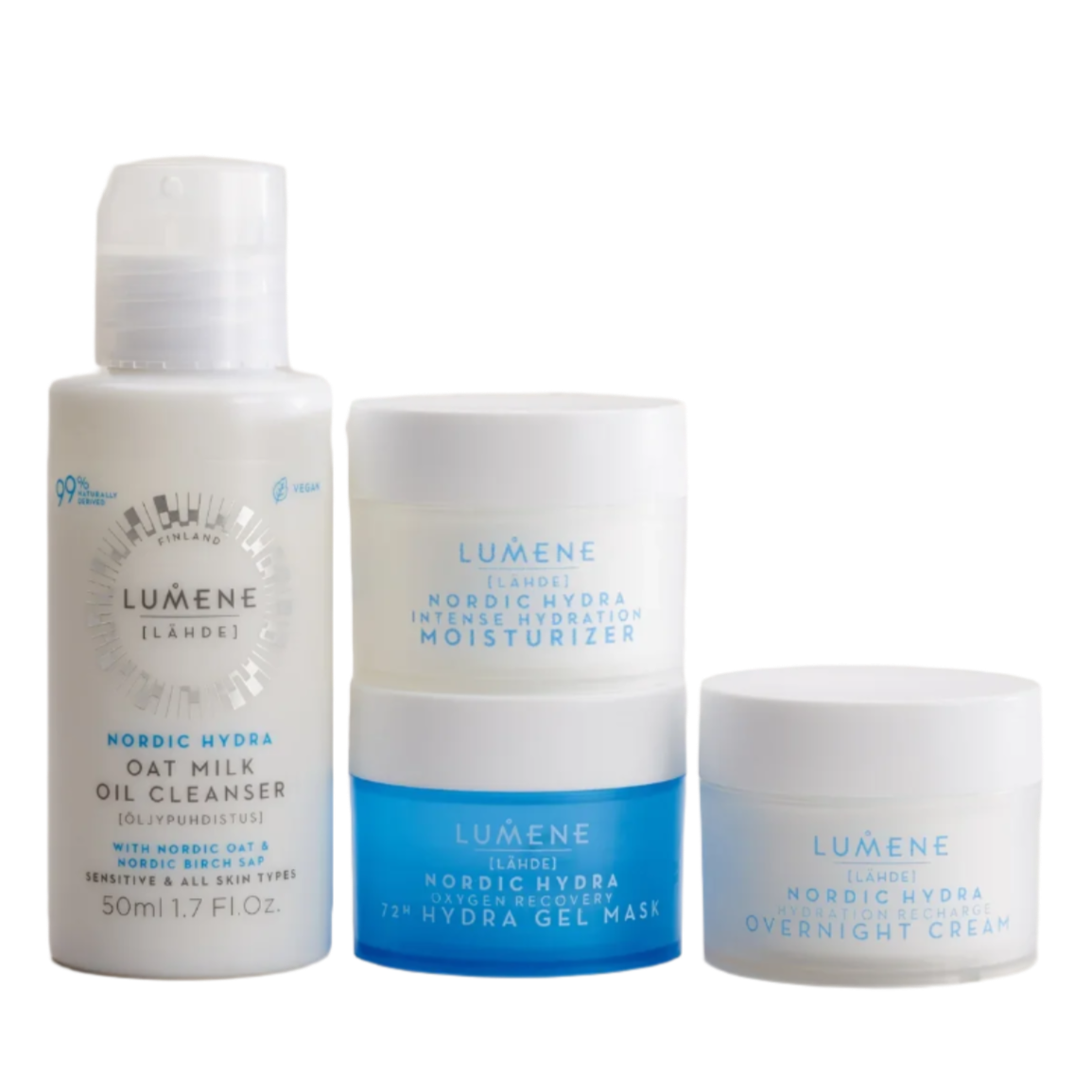 The Lumene Nordic Hydra Travel Kit by Lumene offers Nordic hydration skincare with hyaluronic acid, featuring an Oat Milk Oil Cleanser and three white and blue jars—Moisturizer, 72H Hydra Gel Mask, and Overnight Cream—displayed on white.