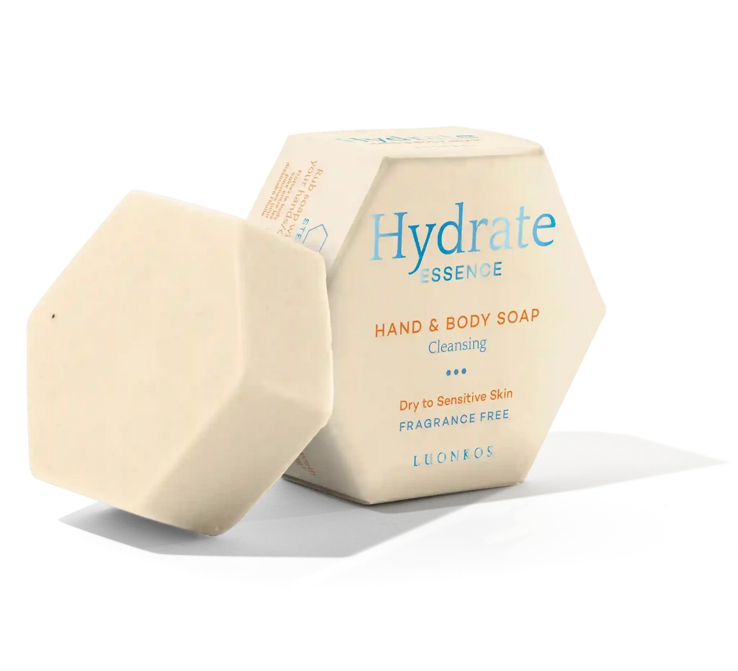 An off-white, hexagonal Luonkos Hydrate Essence Hand & Body Soap bar sits beside its box. Fragrance-free and made with natural plant oils, it's ideal for cleansing and caring for dry or sensitive skin.