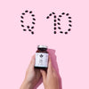 Two hands hold a Puhdistamo High-Strength Q10 Ubiquinone 150 mg bottle; above, black capsules on pink spell "Q10," highlighting Puhdistamo’s role in supporting energy metabolism with this potent ubiquinone supplement.