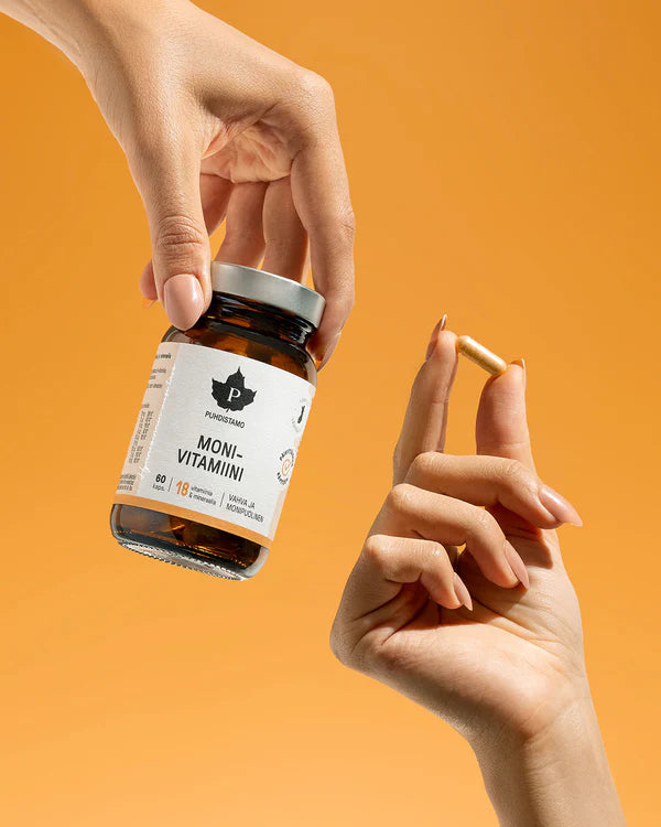 A hand holds a brown bottle labeled Puhdistamo Multivitamin by Puhdistamo for immune support, while another hand shows a single capsule against an orange background.
