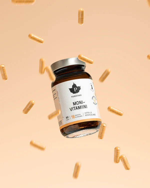 A brown glass bottle labeled Puhdistamo Multivitamin with a silver lid is surrounded by yellow capsules, showcasing Puhdistamo’s multivitamin with active B-vitamins and immune support benefits against a beige background.