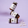 Three bottles of Puhdistamo Strong Probiotic 30 Billion CFU stand stacked against a light purple background, with white capsules nearby—ideal for supporting gut health and immunity.