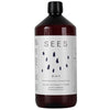 A dark brown bottle of SEES Company 2-in-1 Laundry Detergent with Vinegar features a white label with black droplets, highlighting its eco-friendly formula and natural lavender-peppermint scent for effective odor removal.
