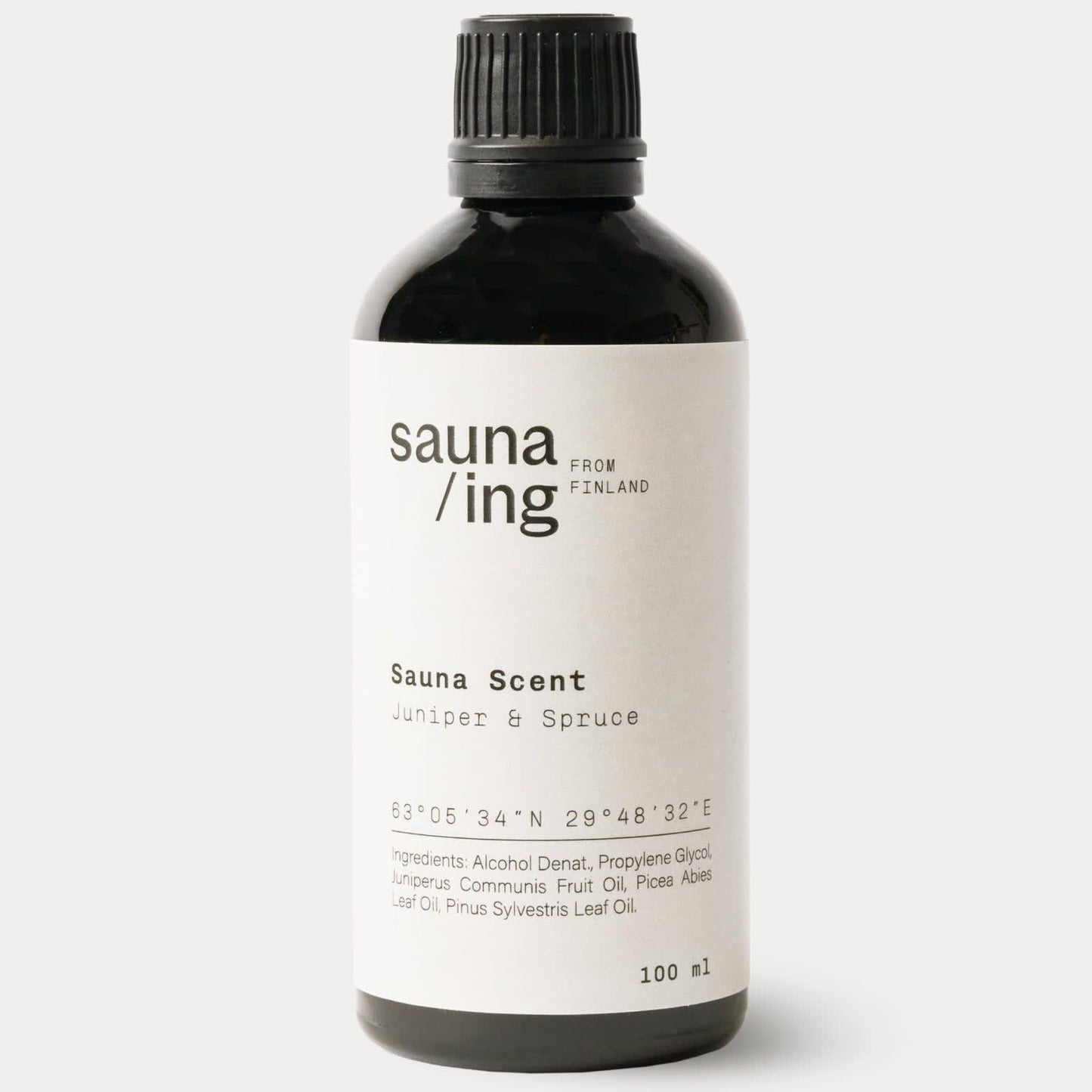 A black 100 ml sauna/ing bottle from Finland labeled "Sauna Scent Juniper & Spruce" features spruce sauna fragrance, coordinates, and ingredients on the front.
