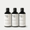 A black bottle of sauna/ing Sauna Scent Spruce & Grape from sauna/ing, featuring a white label and black cap, stands on a white background.