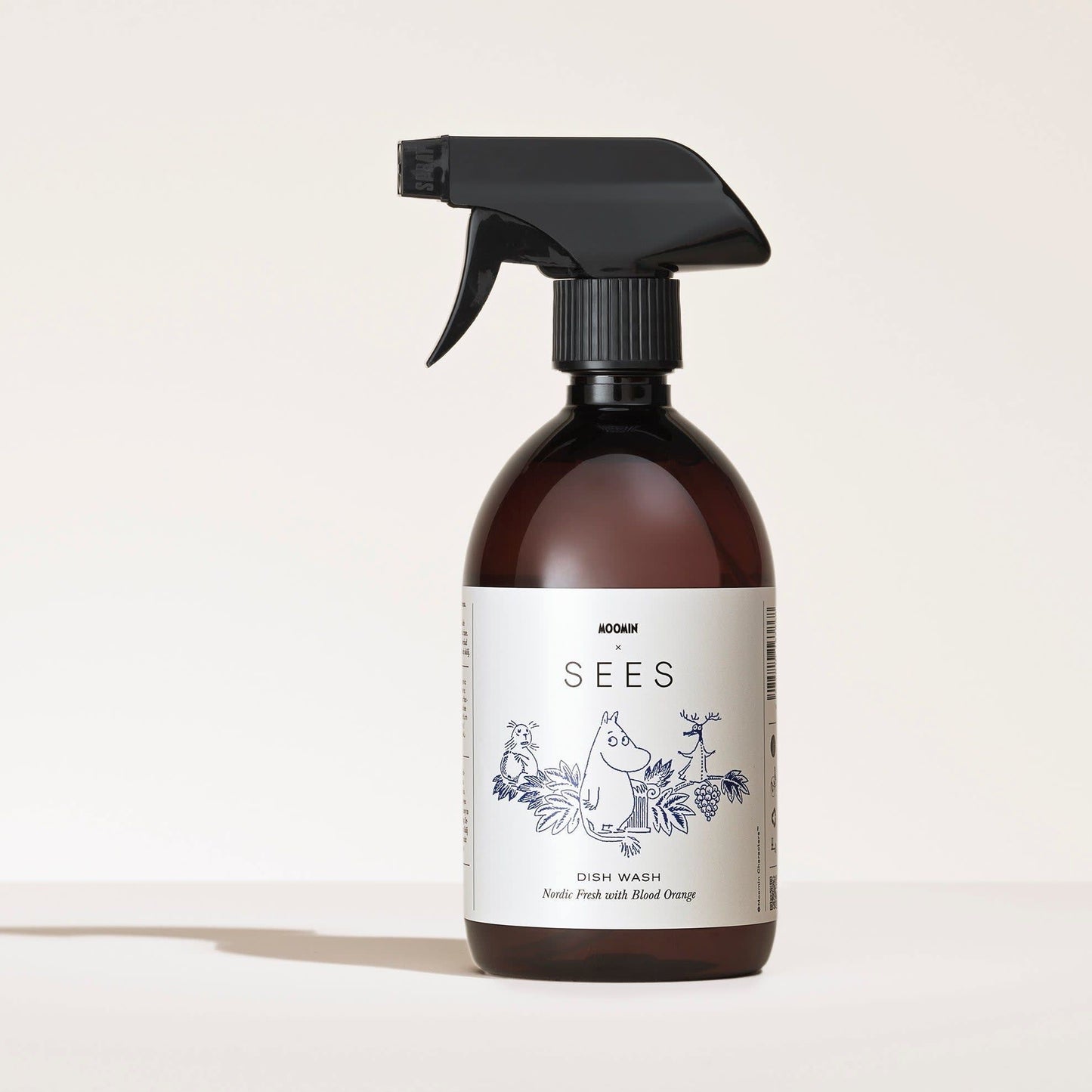 A SEES Company SEES x Moomin Dish Wash Spray, in a brown bottle with cartoon animals and plants, is shown against a light background. This biodegradable dishwashing liquid provides an eco-friendly clean.