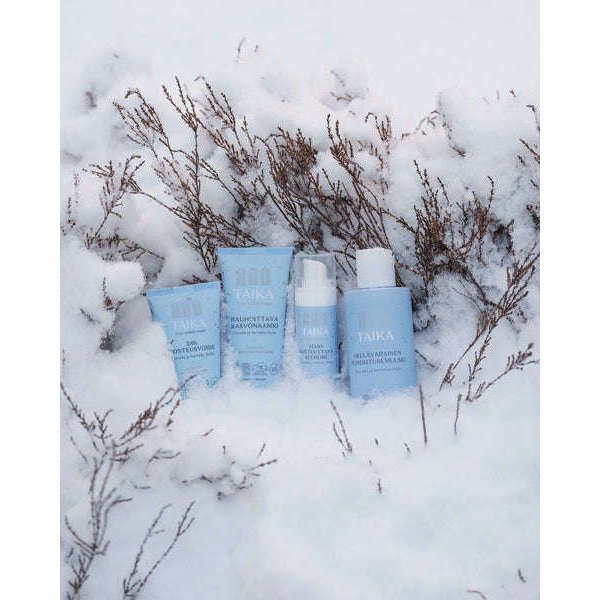 The Taika Sensitive Hydrating Serum, ideal for dry or sensitive skin, stands upright in the snow amid bare, snow-covered branches.