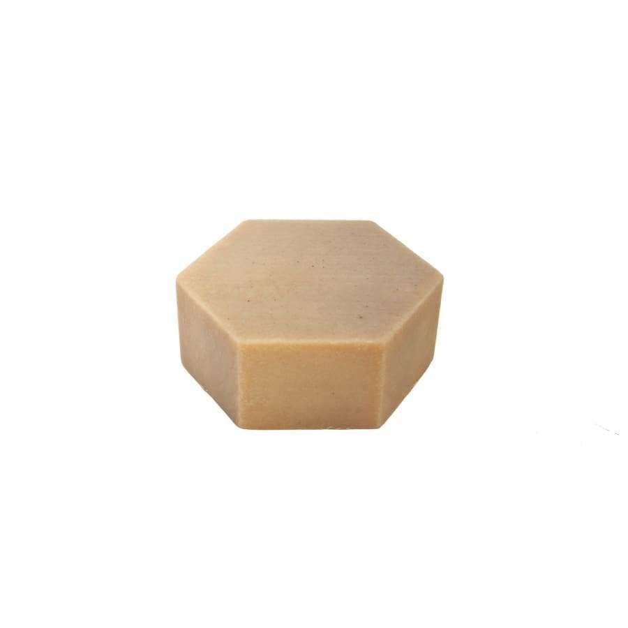 A beige, hexagon-shaped solid bar—Luonkos Rebirth Oil Cleansing Cake by Luonkos, a natural facial cleanser—is centered on a white background.