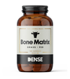 A brown glass bottle of DENSE Bone Matrix by DENSE, featuring a cow head icon, contains 180 capsules of 1000 mg grass-fed beef bone supplement rich in Type I Collagen.