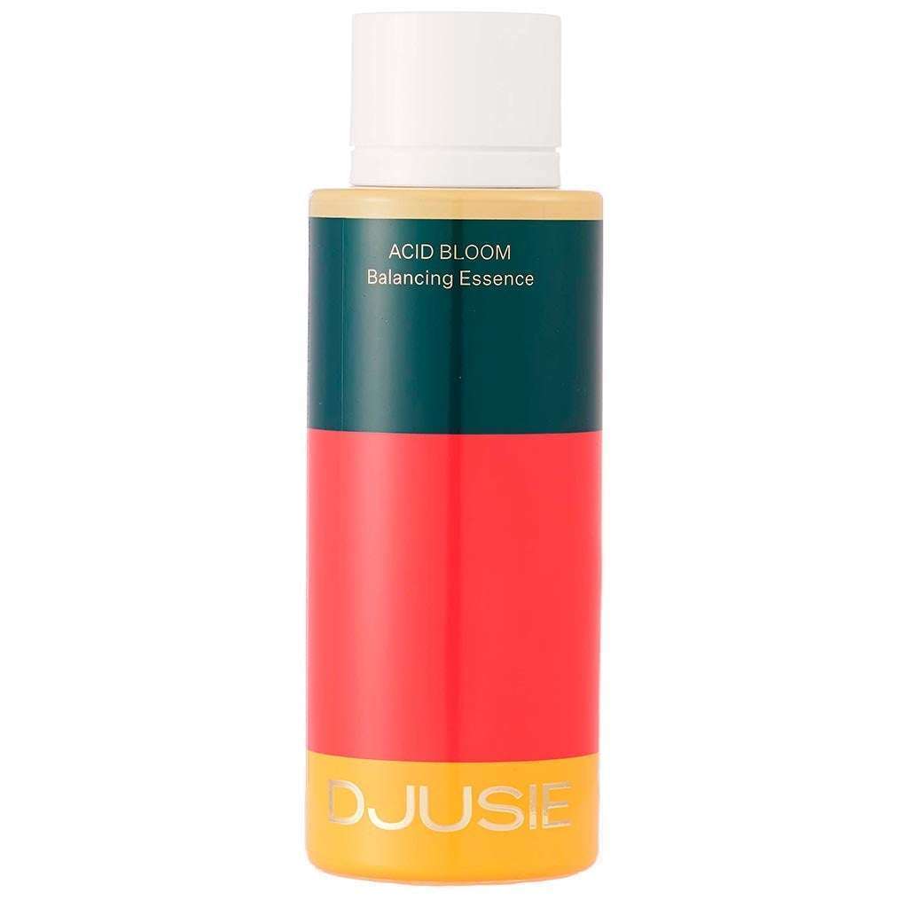 A bottle of Djusie Acid Bloom Balancing Essence with a white cap and a vibrant label in dark green, red, and yellow. This brightening essence by Djusie promotes pH balance, with the product and brand name printed on the label.
