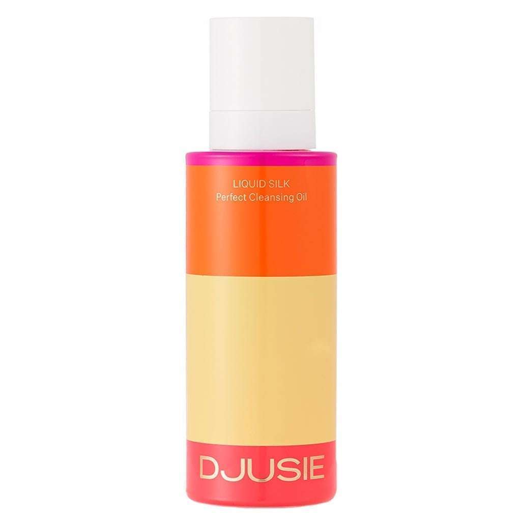 A bottle of Djusie Liquid Silk Perfect Cleansing Oil by Djusie, featuring a bright orange, beige, and pink color block design with a white cap—ideal for removing water-resistant makeup.