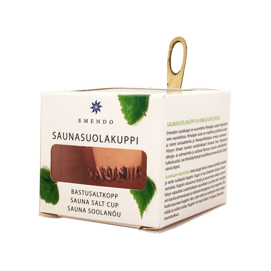 A white box labeled Emendo Stove Cup & Himalaya Salt by Emendo shows a copper cup with brass handle and visible Himalaya salt, ideal for sauna use. The box features green leaf graphics and multilingual product information.