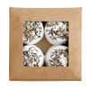 The Kaurilan Sauna Lavender Footbath by Kaurilan Sauna comes in a brown box with a clear window, showing four round white vegan bath bombs topped with dried lavender and arranged in a 2x2 grid.
