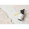 A bottle of Laponie of Scandinavia Face Oil with a dropper, made for sensitive skin, rests on a marble surface with some spilled oil. Light stone textures appear in the background.