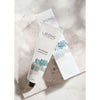 A tube of Laponie of Scandinavia Gel Cleanser for sensitive skin sits on a marble surface, with its box in the background. Both packaging designs are minimalist and feature abstract blue and beige artwork.