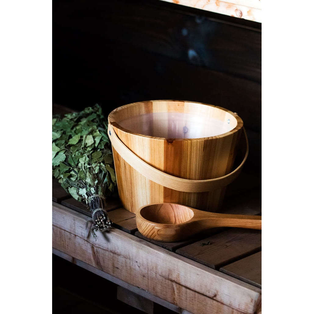 The Emendo Sauna Fragrance Forest by Emendo sits on a wooden bench, ready to infuse your sauna rituals with the calming scent of the forest.