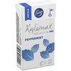 A box of Fazer Xylimax Peppermint Full Xylitol Pastilles features blue leaf designs, marked 100% Xylitol Pro and Peppermint. Icons emphasize tooth-friendly dental benefits and Finnish origin. Brand: Fazer.