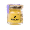 A small glass jar of Havuka Lavender Balm with a gold lid is covered in water droplets. The yellow cream inside, marked with the Havuka logo, offers gentle eczema relief with each application.
